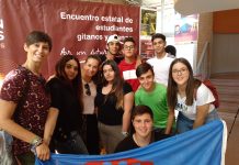 Grupo de estudiantes sosteniendo la bandera gitana