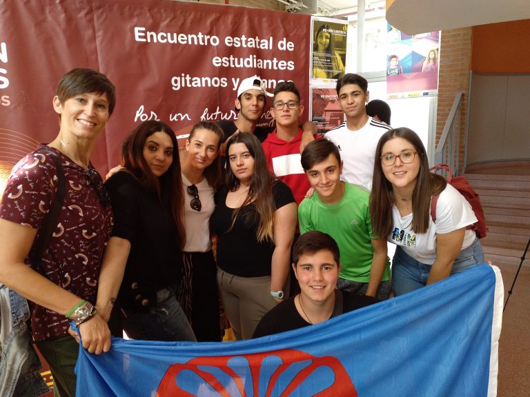 Grupo de estudiantes sosteniendo la bandera gitana